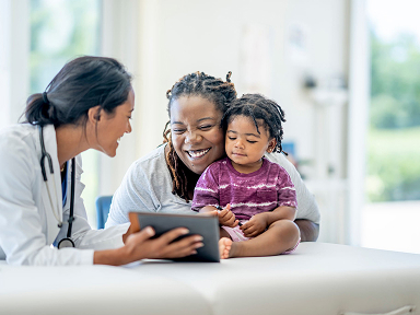 Doctor with baby patient and her mother